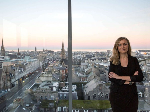 woman next to a window with a view over Aberdeen woman next to a window with a view over Aberdeen